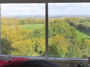 A room with a large window overlooking a green landscape with trees and a golf course.
