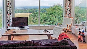 A room with a large window, a television, a table with a chair, and a sofa. - 4 Person Holiday Home in Veberod-by Traum (Veberöd)