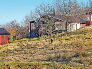A rural landscape with a house on a hill, surrounded by trees and grass. - 4 Person Holiday Home in Veberod (Veberöd)