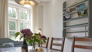 A dining table with a bottle of wine, two wine glasses, and a bowl of fruit. - 10 Person Holiday Home in Nexo (Nexø)