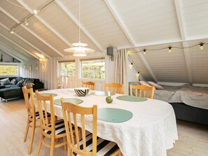 A dining area with a round table, chairs, and a ceiling light fixture.