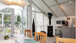 A cozy interior with a dining area, a fireplace, and a kitchen.