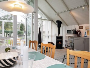 A cozy interior with a dining area, a fireplace, and a kitchen.