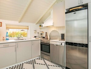 A modern kitchen with white cabinets, a stainless steel refrigerator, a Bosch oven, and a checkered floor.