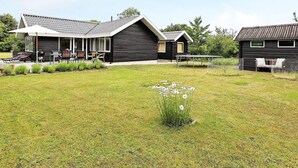 A house with a covered patio, a lawn, and a small garden. - 4 Star Holiday Home in Karrebaeksminde (Karrebæksminde)