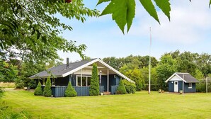 A two-story house with a large front lawn, a covered porch, and a small adjacent shed. - 6 Person Holiday Home in Oksbol-by Traum (Oksbol)