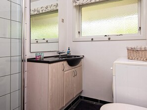A compact bathroom with a sink, mirror, and window.