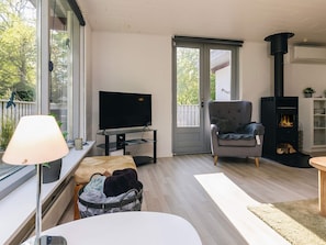 A living room with a television, a fireplace, and a comfortable seating area. - 6 Person Holiday Home in Hadsund (Hadsund)