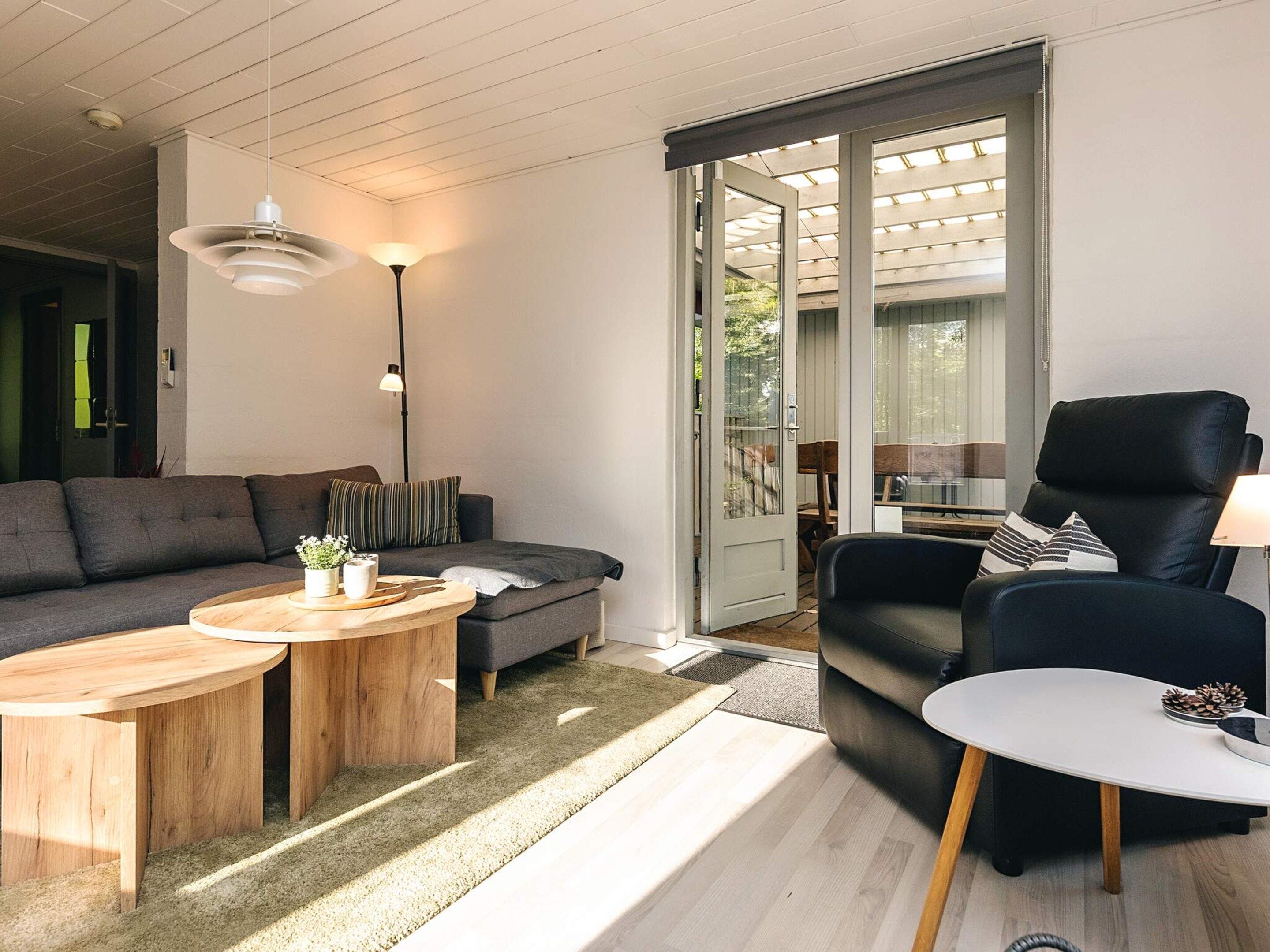 A modern living room with a sofa, coffee table, and a black leather chair.