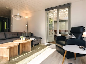 Un salon moderne avec un canapé, une table basse et un fauteuil en cuir noir.