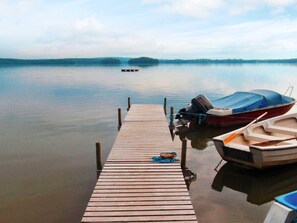 A wooden dock extending into calm water with boats moored at the end. - 4 Person Holiday Home in Kristianstad (Kristianstad)