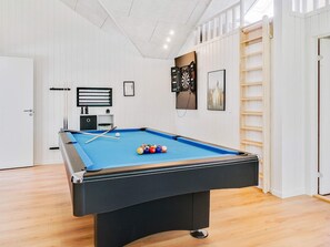 A pool table in a room with white walls, a door, and a framed picture on the wall. - 5 Star Holiday Home in Vaeggerlose (Vaeggerlose)