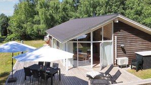 A wooden deck with outdoor furniture, a covered patio area, and a glass-enclosed room. - 4 Star Holiday Home in Laeso (Læsø)
