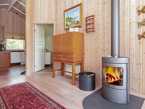 Une pièce chaleureuse avec un poêle à bois, un meuble en bois et un tapis.