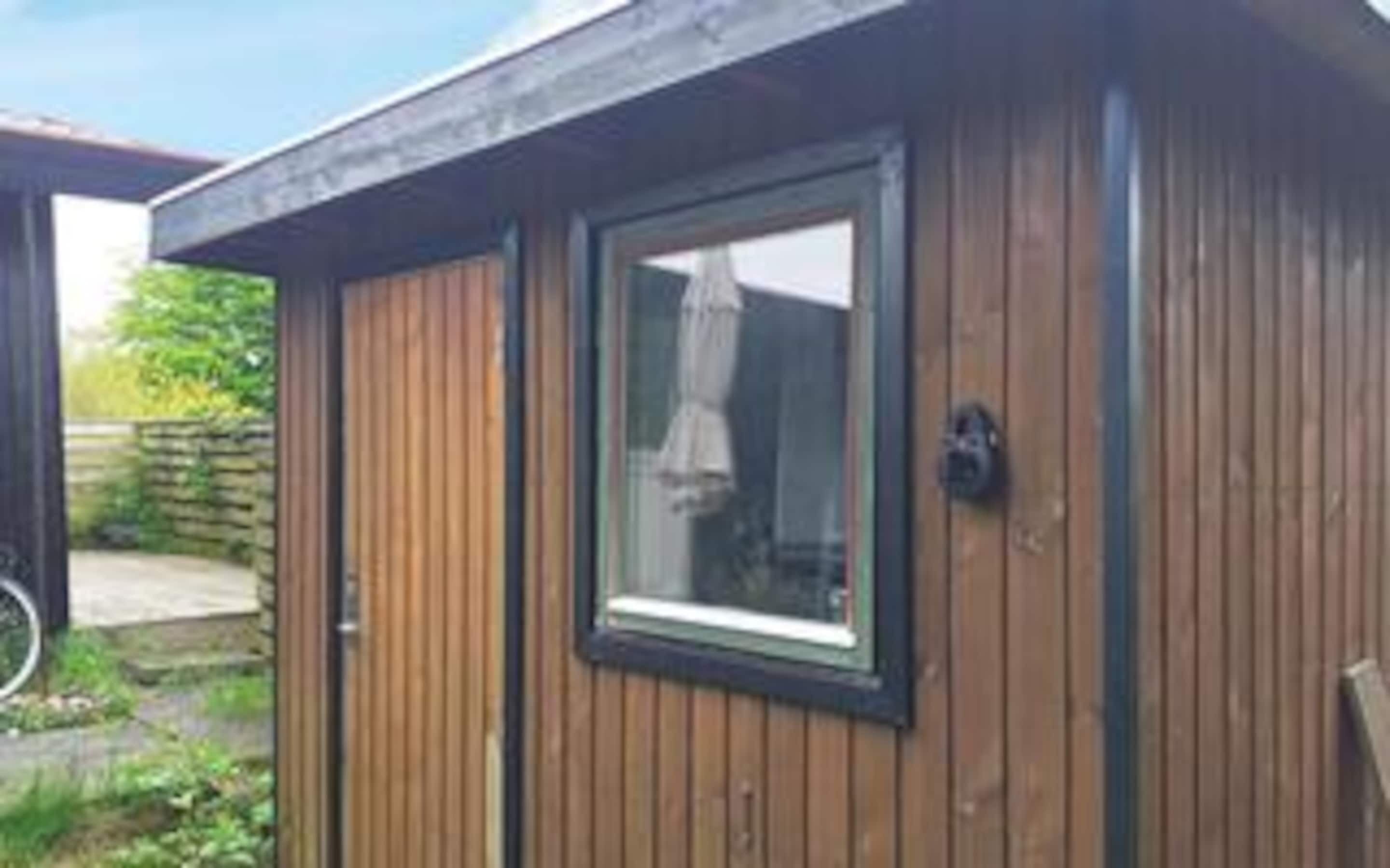 A wooden building with a window and a door.