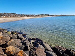 A coastal landscape with clear water, a sandy beach, and rocky shoreline. - 5 Star Holiday Home in Knebel (Knebel)