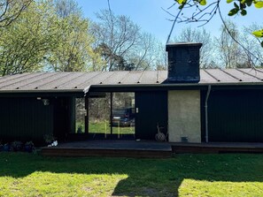 A single-story building with a flat roof, a chimney, and a glass door entrance. - 5 Star Holiday Home in Knebel (Knebel)