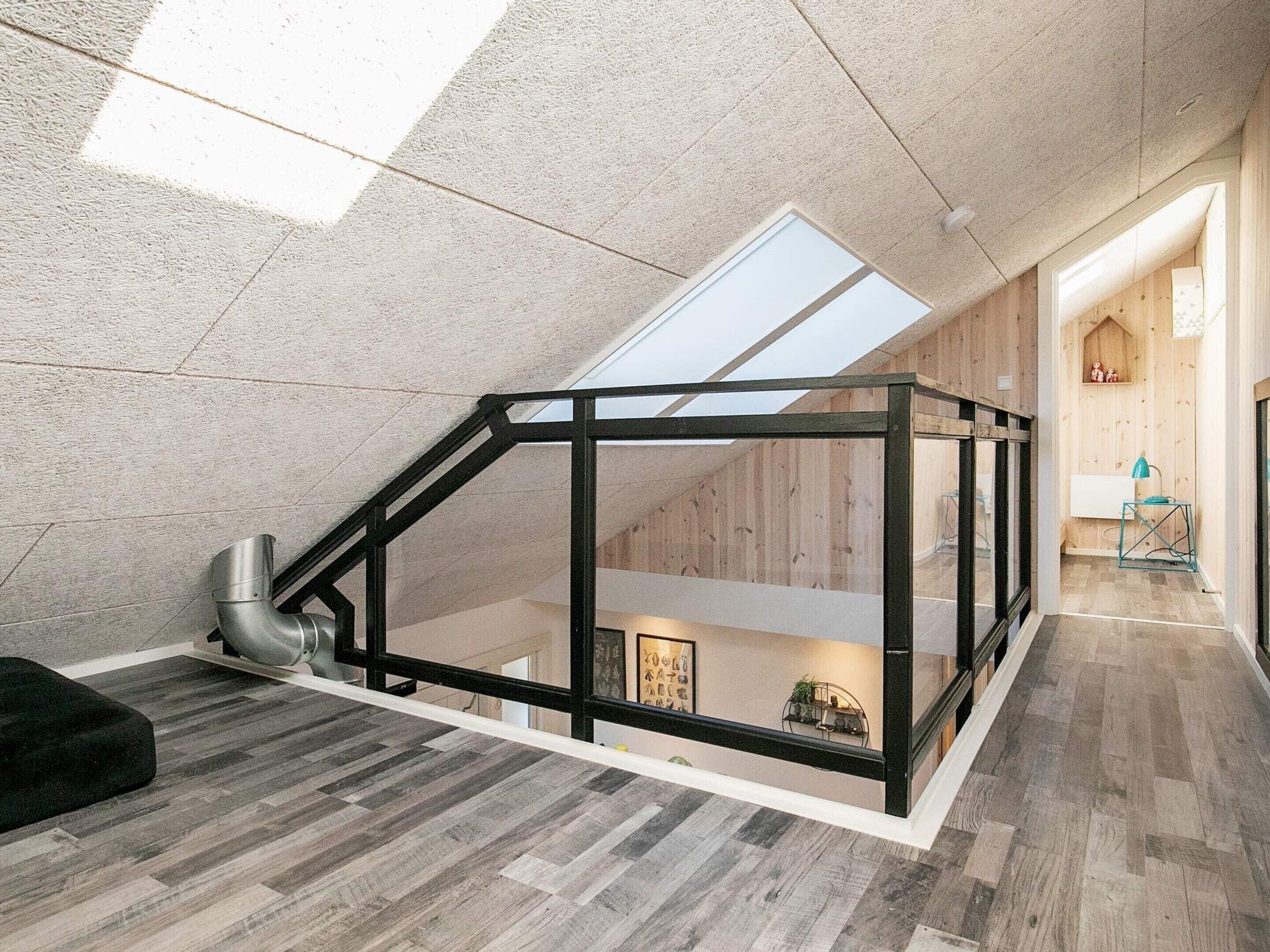 Ein modernes Loft mit Dachfenster, Holzboden und einer erhöhten Zwischenebene.