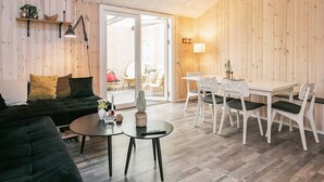 Un soggiorno moderno con un divano, un tavolino rotondo e un'area pranzo con tavolo e sedie.