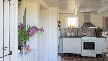 A kitchen with white cabinets, a tiled floor, and a window with a view.