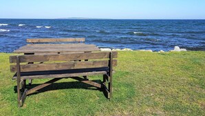 A wooden bench facing the ocean with a grassy foreground. - 6 Person Holiday Home in Solvesborg (Sölvesborg)