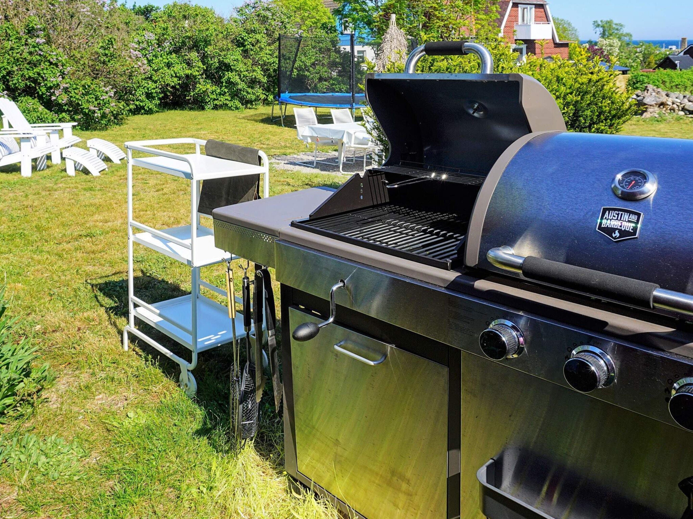 A stainless steel barbecue grill with a digital thermometer and a logo that reads 'Austin and Ramsey BBQ.'