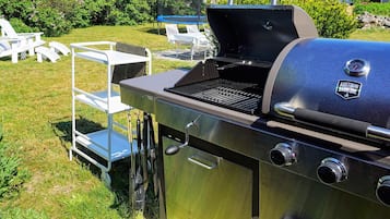 A stainless steel barbecue grill with a digital thermometer and a logo that reads 'Austin and Ramsey BBQ.'