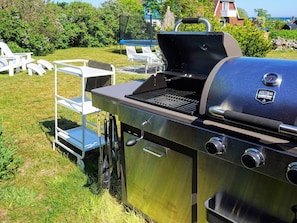 A stainless steel barbecue grill with a digital thermometer and a logo that reads 'Austin and Ramsey BBQ.'