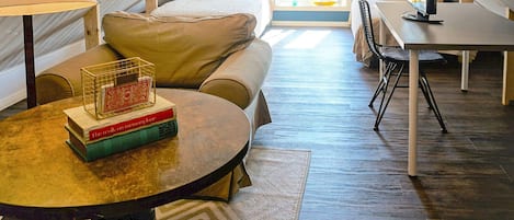 A cozy attic bedroom with a bed, a desk, and a table with books.