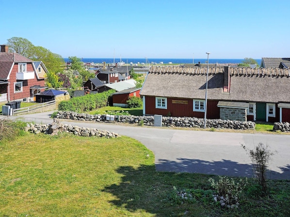 A coastal village with traditional houses, a stone wall, and a clear view of the sea.