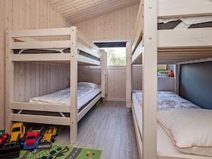 A bunk bed room with wooden walls and a window. - 5 Star Holiday Home in Vaeggerlose (Vaeggerlose)