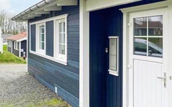 A single-story building with a dark blue exterior, white trim, and a white door.