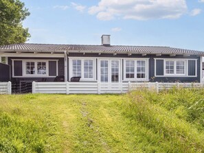 A two-story house with a porch, white railings, and a grassy yard. - 4 Star Holiday Home in Aabenraa (Aabenraa)