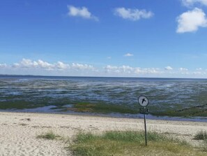 En strand med et skilt, der angiver et område med livredder.