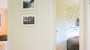 A room with a bed, a door leading to another room, and two framed pictures on the wall. - 4 Star Holiday Home in Ljungskile (Ljungskile)