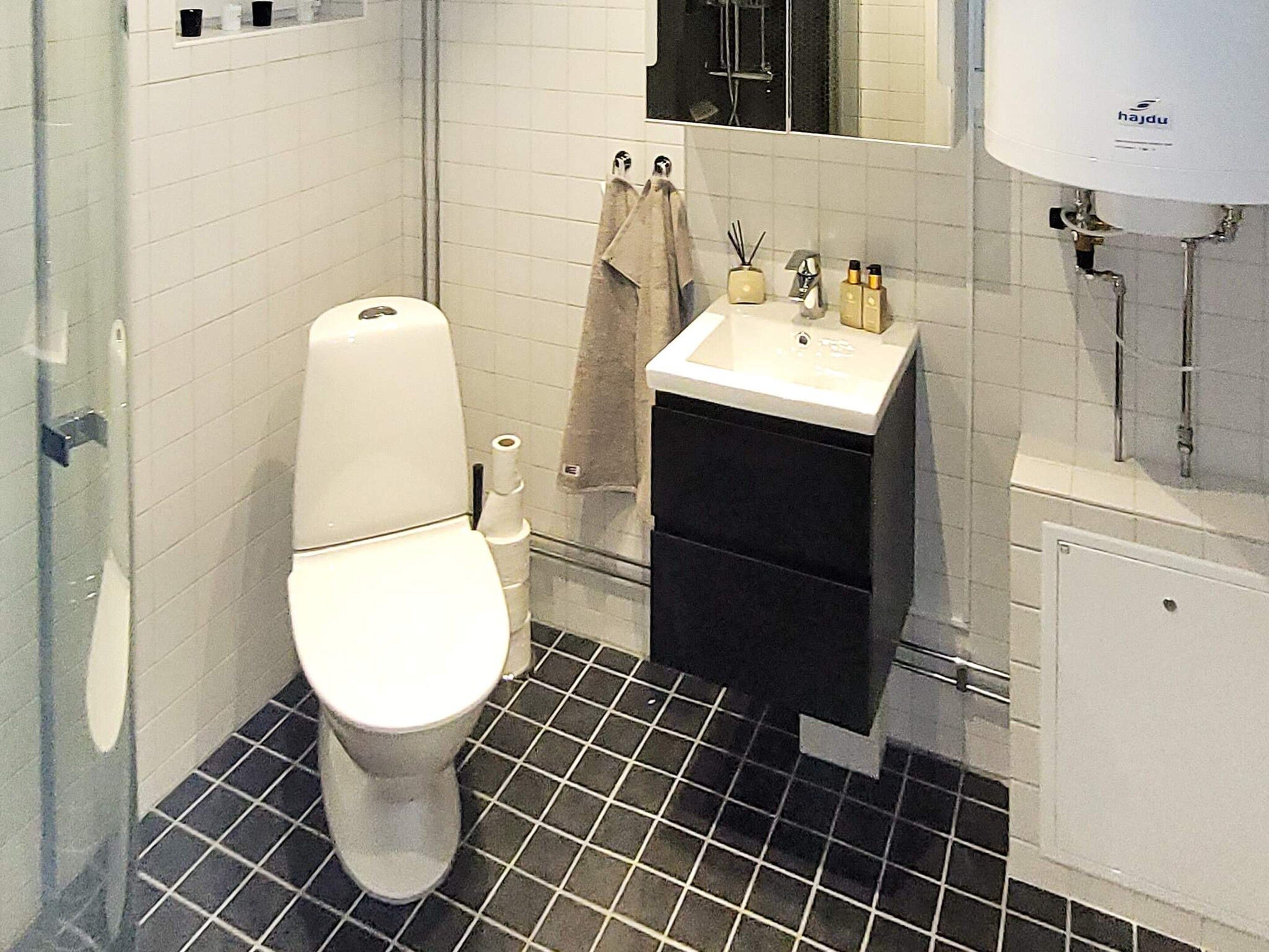 Un baño con inodoro, lavamanos y espejo.