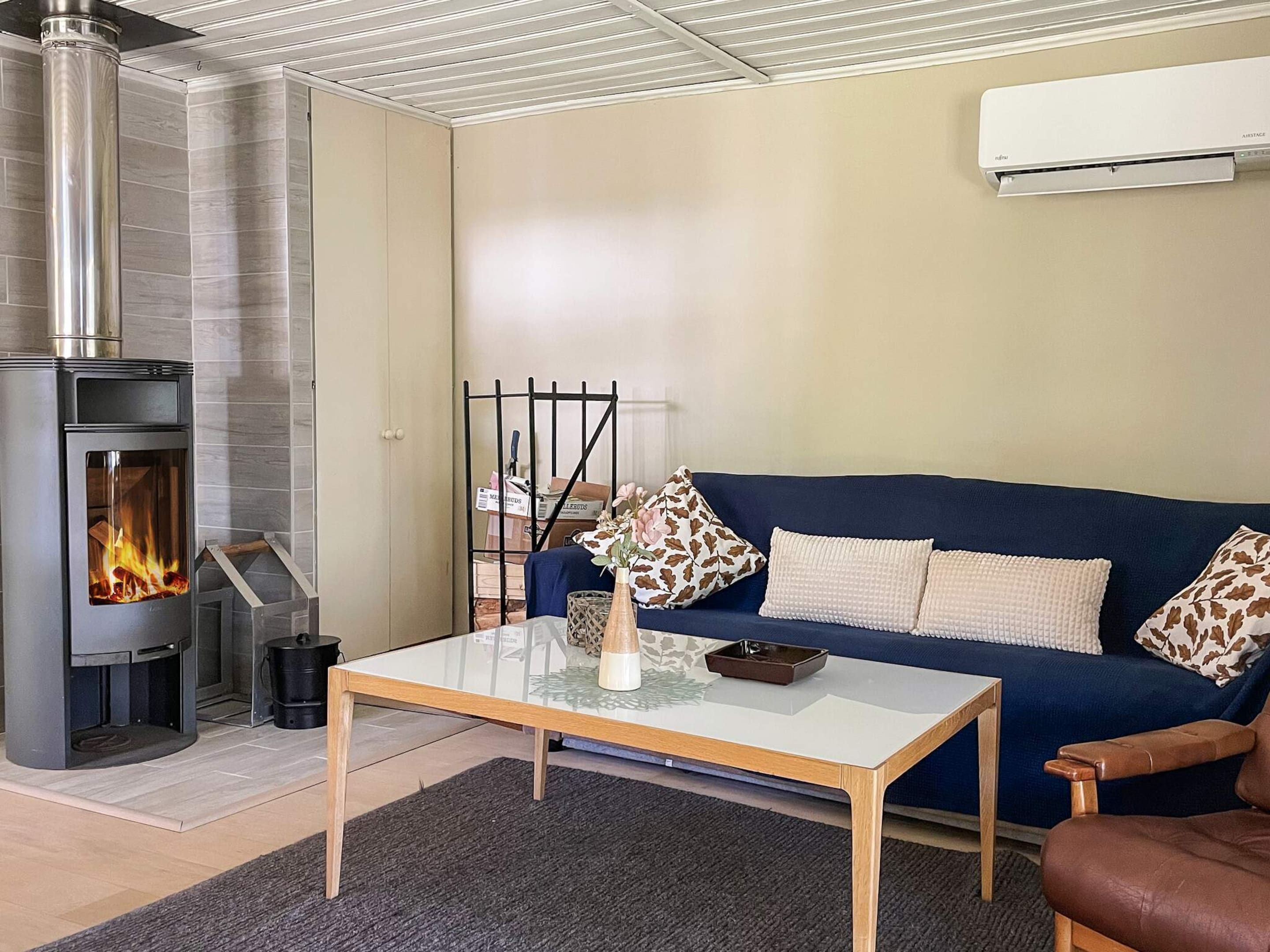 Ein Wohnzimmer mit Kamin, einer Couch, einem Couchtisch und einer Klimaanlage.