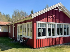 A red wooden building with large windows and a white trim. - 4 Star Holiday Home in Hacksvik (Håcksvik)