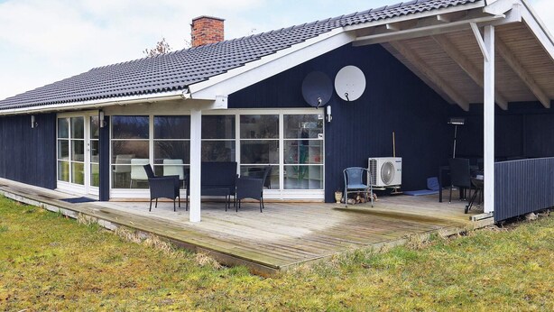 A modern house with a covered porch, large windows, and a satellite dish. - 6 Person Holiday Home in Idestrup (Idestrup)