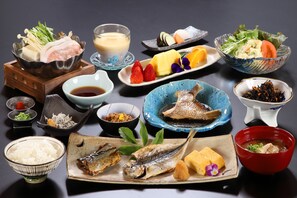 Een verscheidenheid aan Japanse gerechten, waaronder vis, tofu en groenten, gepresenteerd op een tafel.