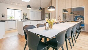 A modern kitchen with white cabinets, a large island, and pendant lighting.