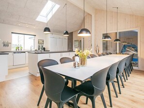 A modern kitchen with white cabinets, a large island, and pendant lighting.
