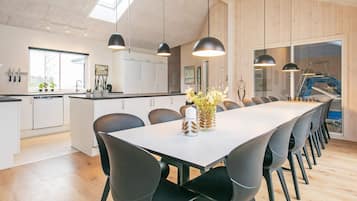 A modern kitchen with white cabinets, a large island, and pendant lighting.