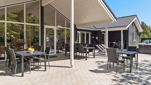 Ein Außenbereich mit Terrassenmöbeln, ein überdachter Sitzbereich und ein Whirlpool.