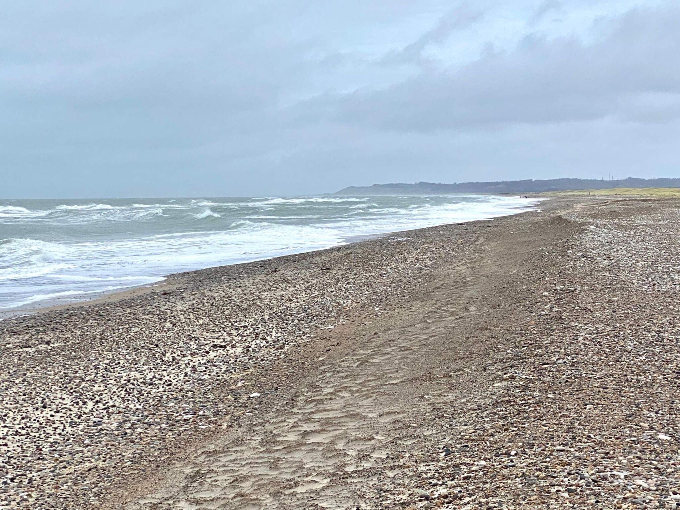 A pebbly beach with waves crashing onto the shore.