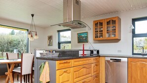 A modern kitchen with wooden cabinets, a central island, and a dishwasher. - 8 Person Holiday Home in Romo (Rømø)