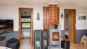 A cozy living room with a fireplace, a television, and a sofa. - 8 Person Holiday Home in Romo (Rømø)