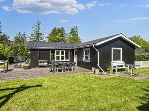 A black wooden house with a patio, outdoor seating, and a grill. - 6 Person Holiday Home in Tarm (Tarm)