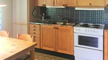 Una cocina con armarios de madera, estufa y refrigerador.