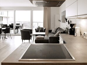 Relax in a spacious living area with a dining table, comfortable sofa, and kitchen facilities.
